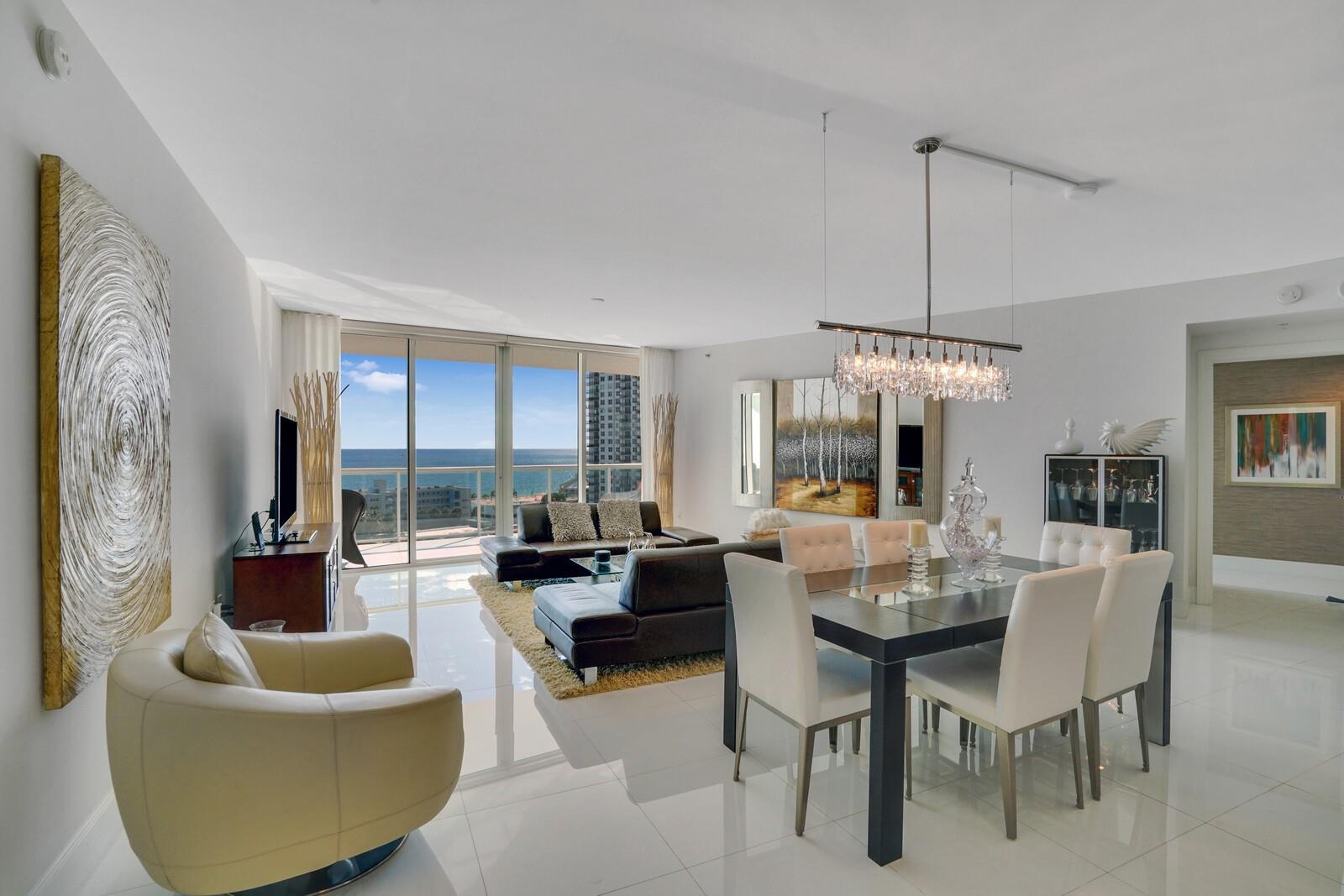 A modern open-concept living and dining room with white tile floors and ocean views — 1 N Ocean Boulevard # 903, Pompano Beach FL 33062, POMPANO BEACH, FL