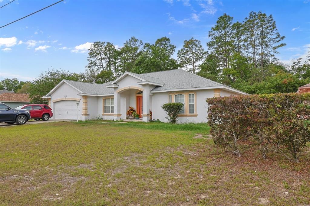 A single-story house with a light-colored stucco exterior, a two-car garage, and a front lawn — 13536 SW 81ST CIRCLE, OCALA, FL