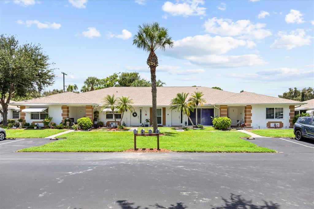A single-story multi-unit residential building with a central palm tree and a shared lawn — 127 LAKES END DRIVE UNIT C, FORT PIERCE, FL