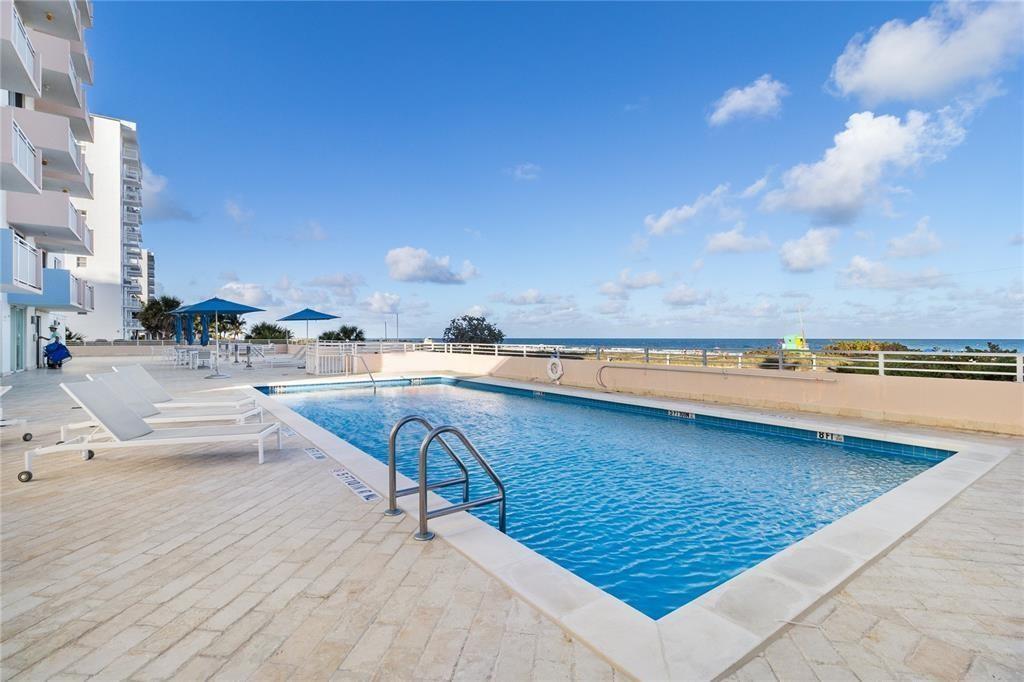 A rectangular swimming pool sits on a paved deck overlooking the ocean — 345 Ocean Drive # 512, Miami Beach FL 33139, MIAMI BEACH, FL