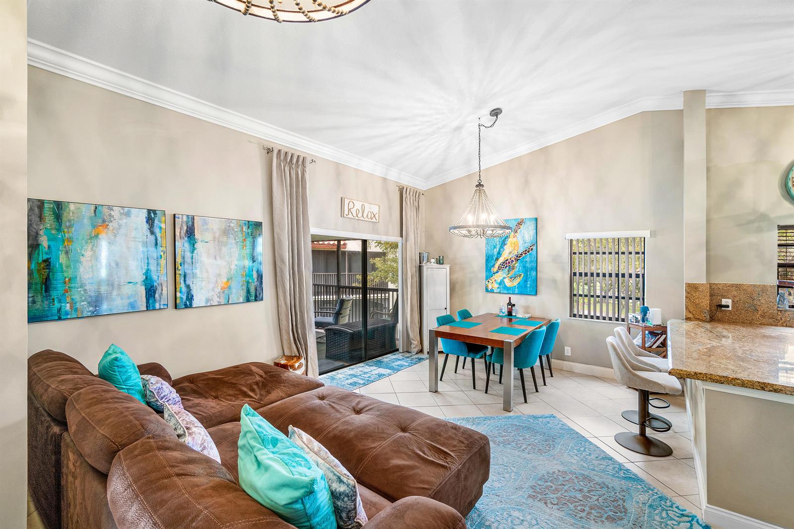 A living and dining area features a brown sectional, blue accents, and a chandelier — 312 Liberty Court, Deerfield Beach FL 33442, DEERFIELD BEACH, FL