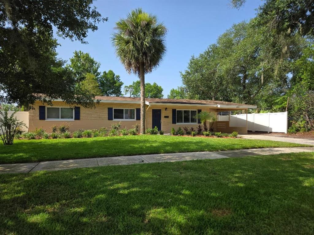 A single-story house with tan brick siding, dark shutters, and a palm tree in front — 2010 SUMMERFIELD ROAD, WINTER PARK, FL