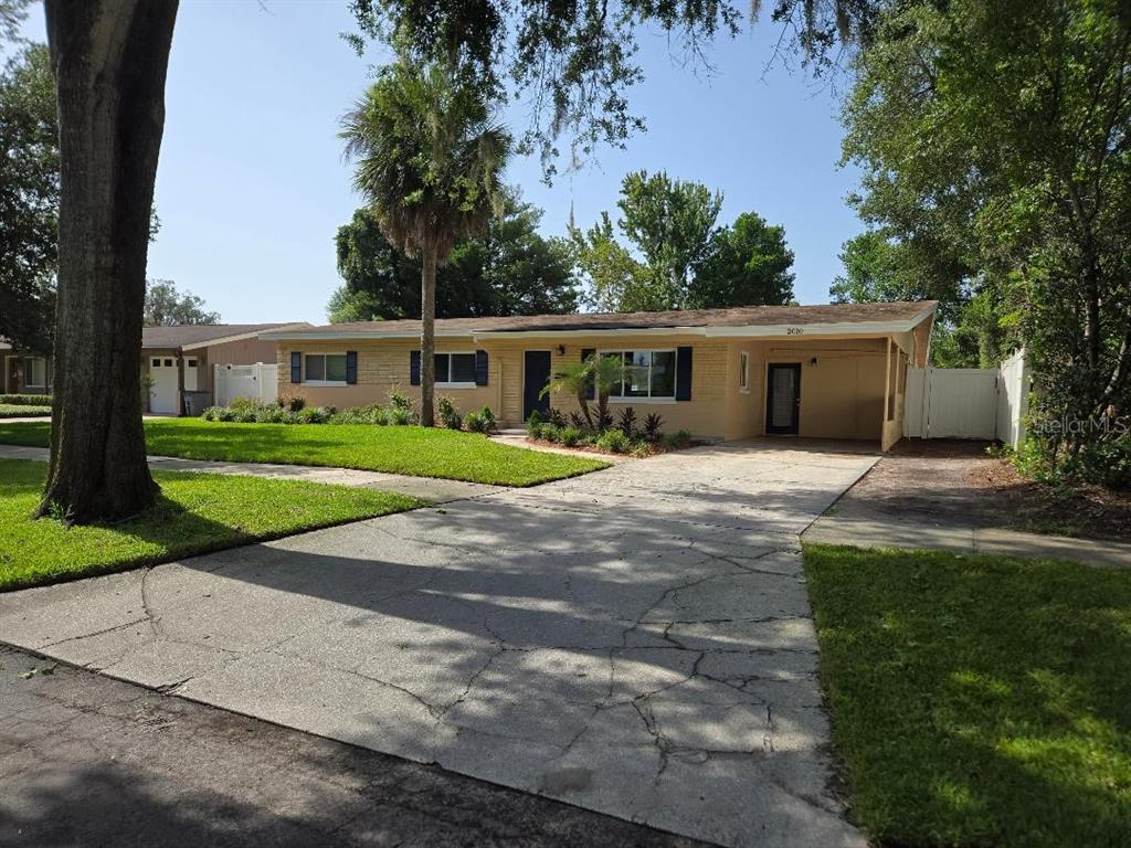 A single-story house with a tan brick exterior, a concrete driveway, and a carport — 2010 SUMMERFIELD ROAD, WINTER PARK, FL