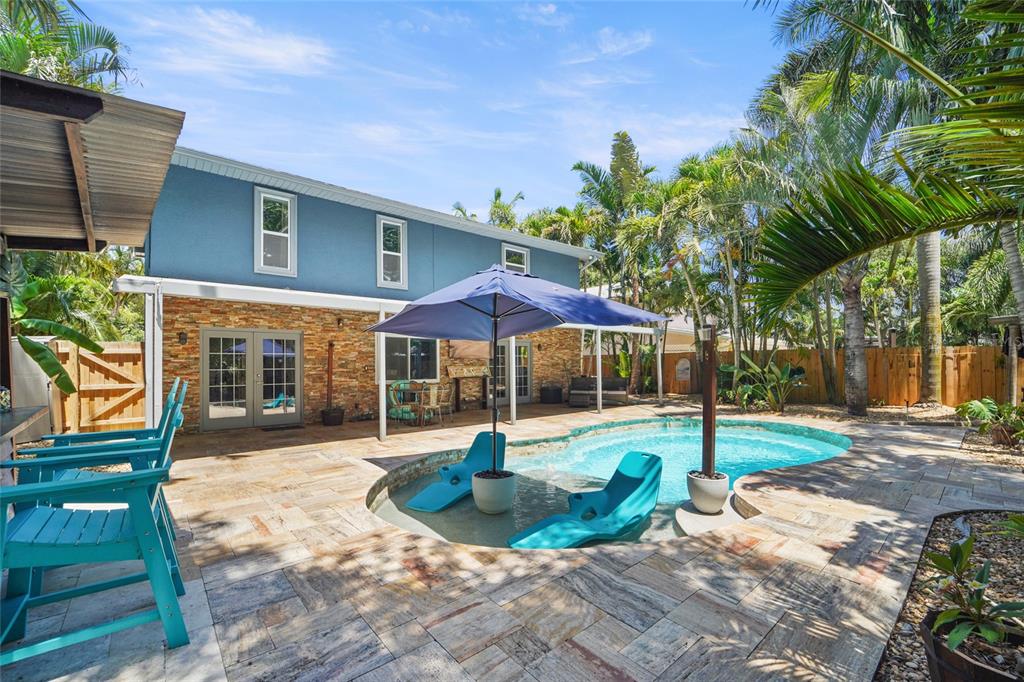 A living room with a brown sectional sofa, wood-look flooring, and an adjacent blue-cabinet kitchen — 9545 135TH STREET, SEMINOLE, FL