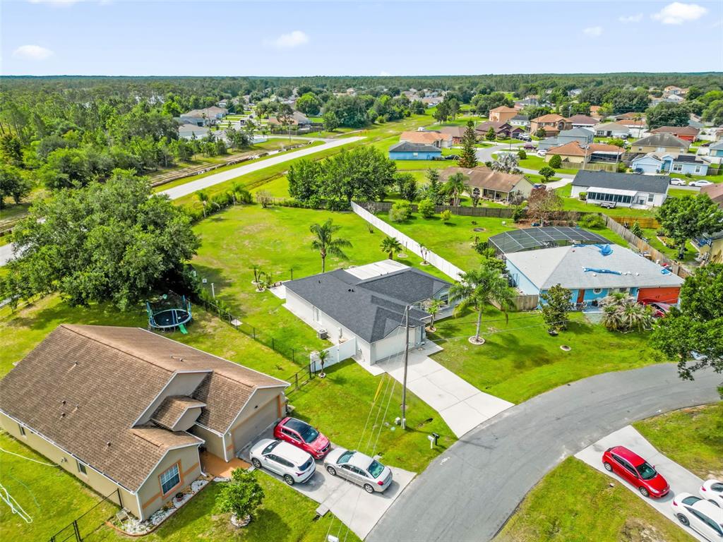 An aerial view shows several suburban houses with driveways and lawns in a residential neighborhood — 1147 NORMANDY DRIVE, KISSIMMEE, FL