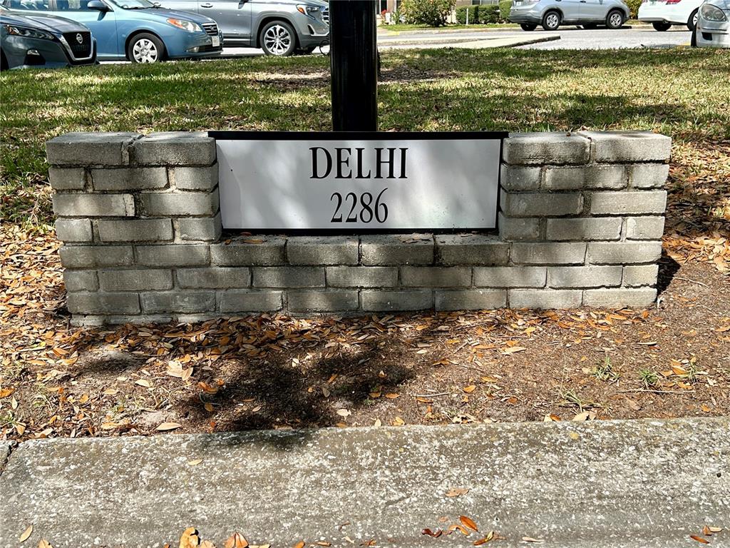A brick monument sign displays the text DELHI 2286 in a grassy area — 2286 NORWEGIAN DRIVE UNIT 8, CLEARWATER, FL