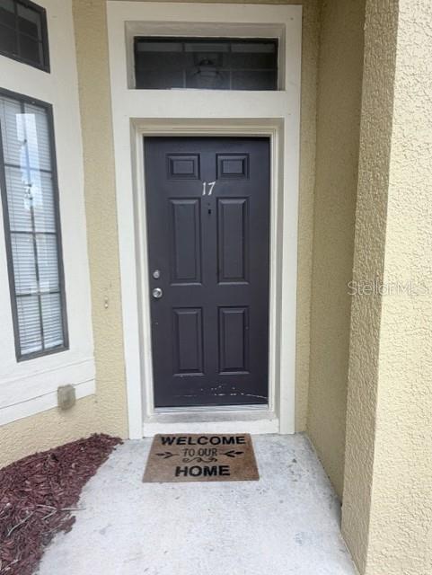 A dark gray front door with the number 17 is framed by a white entryway — 6013 SCOTCHWOOD GLEN UNIT 17, ORLANDO, FL