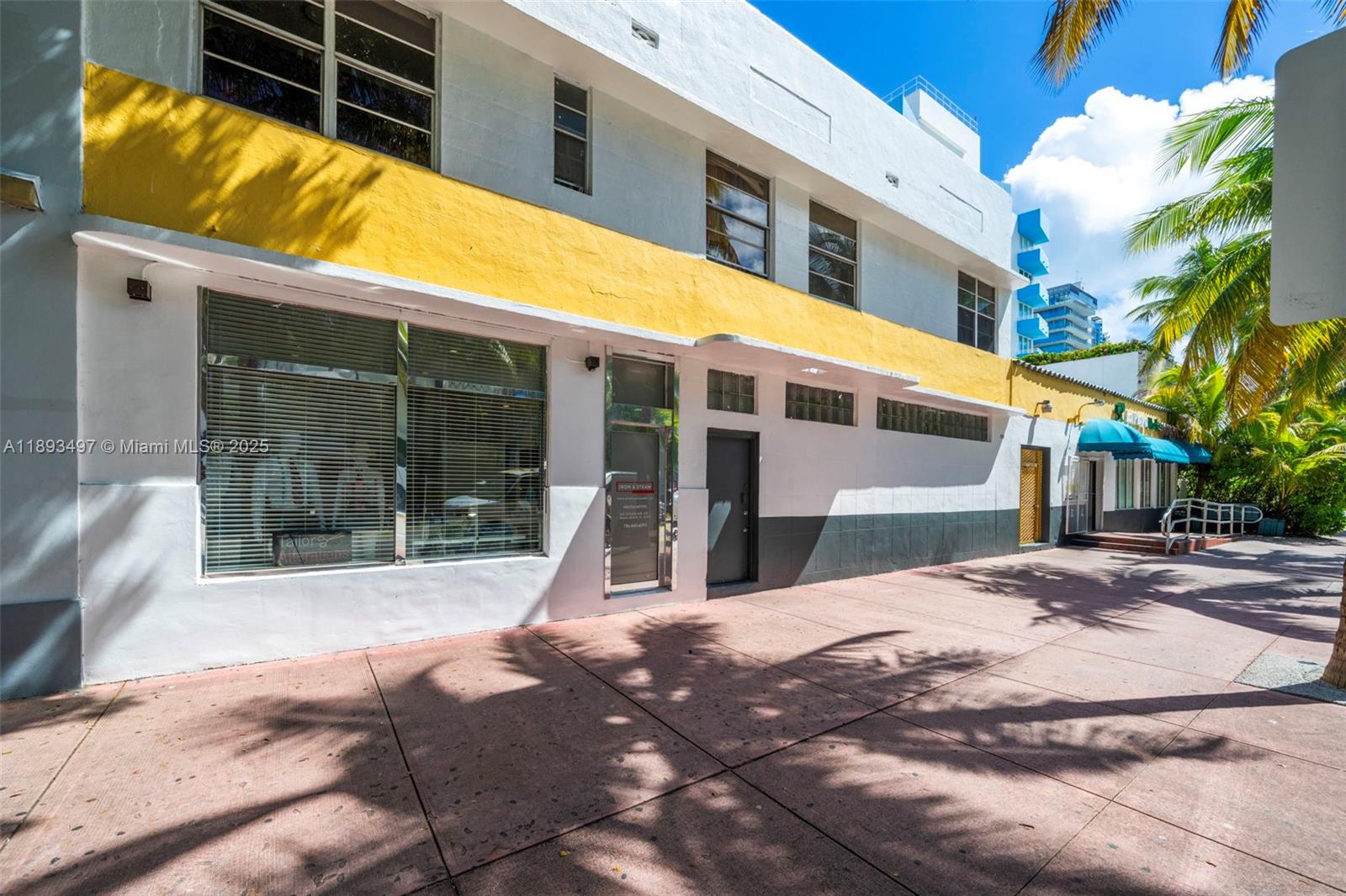 The exterior of a white and yellow Art Deco building features large storefront windows — 249 Collins Ave, Miami Beach FL 33139, MIAMI BEACH, FL