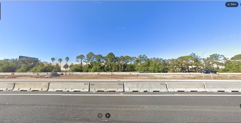 A view of a vacant lot bordered by a highway and concrete construction barriers — I-4, POLK CITY, FL