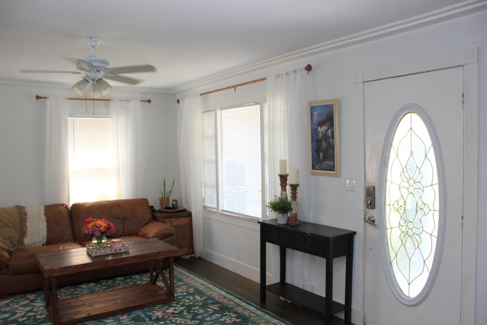 A living room features a brown leather sofa, wood coffee table, and a white front door — 237 Wenonah Place, West Palm Beach FL 33405, WEST PALM BEACH, FL