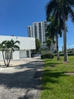 A white building stands next to a tall apartment tower with palm trees in front — 3621 NE Miami Ct, Miami FL 33137, MIAMI, FL