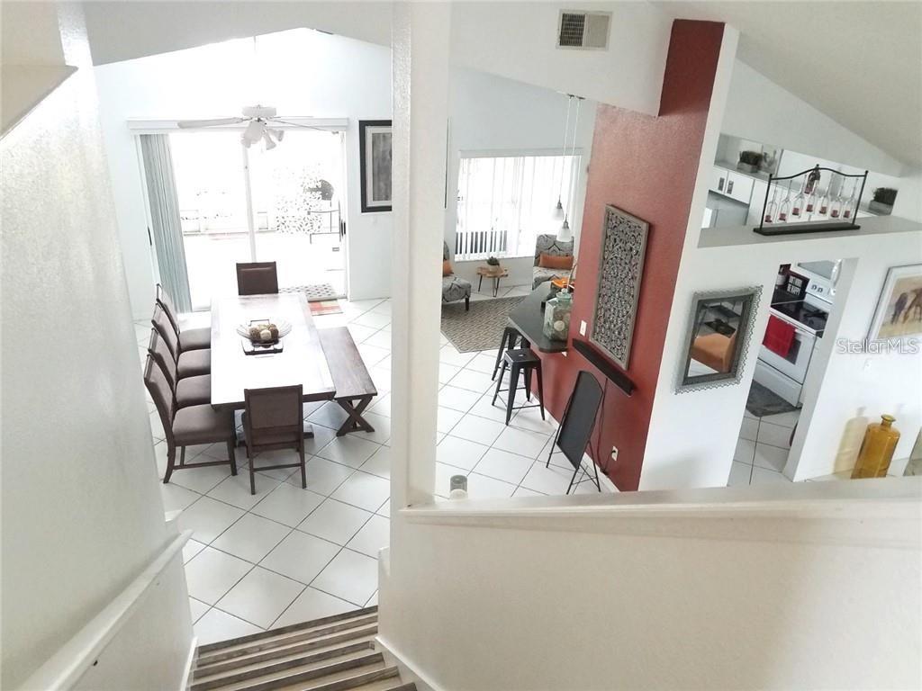 A high-angle view shows a dining area and kitchen with tile floors and vaulted ceilings — 11859 HARTFORDSHIRE WAY, ORLANDO, FL