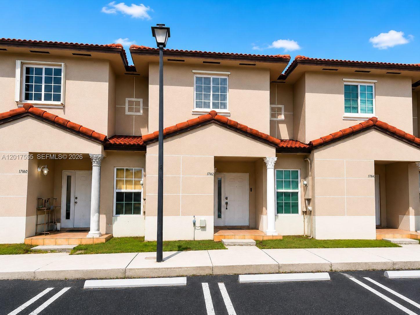 A row of three beige two-story townhouses features red tile roofs and white trim — 17184 SW 138th Ct, Miami FL 33177, MIAMI, FL