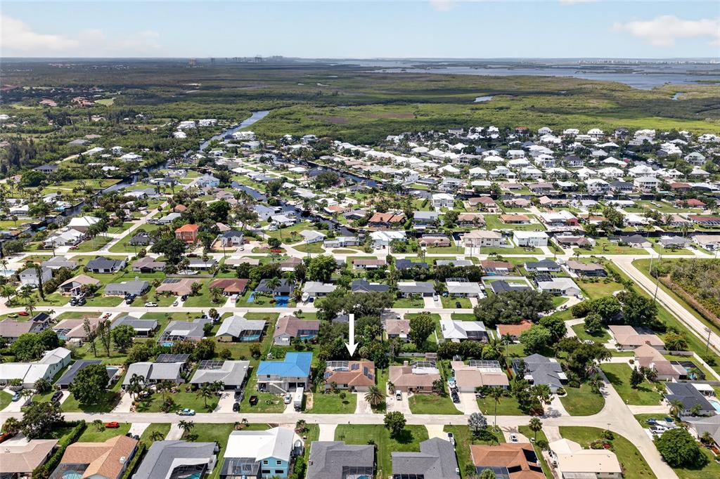 An aerial view shows a residential neighborhood with a white arrow pointing to a house — 6049 PERTHSHIRE LANE, FORT MYERS, FL