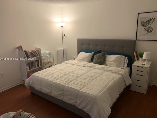 A bedroom features a gray upholstered bed, a white bookshelf, and a white nightstand — 7035 NW 186th St # D310, Hialeah FL 33015, HIALEAH, FL