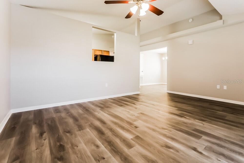 An empty room with light-colored walls, wood-look flooring, and a ceiling fan — 11730 LYNN BROOK CIRCLE, SEFFNER, FL