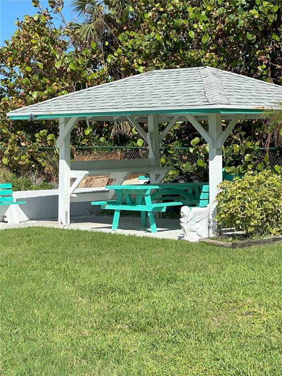 A turquoise picnic table sits under a white gazebo in a grassy yard — GULF BOULEVARD, REDINGTON SHORES, FL