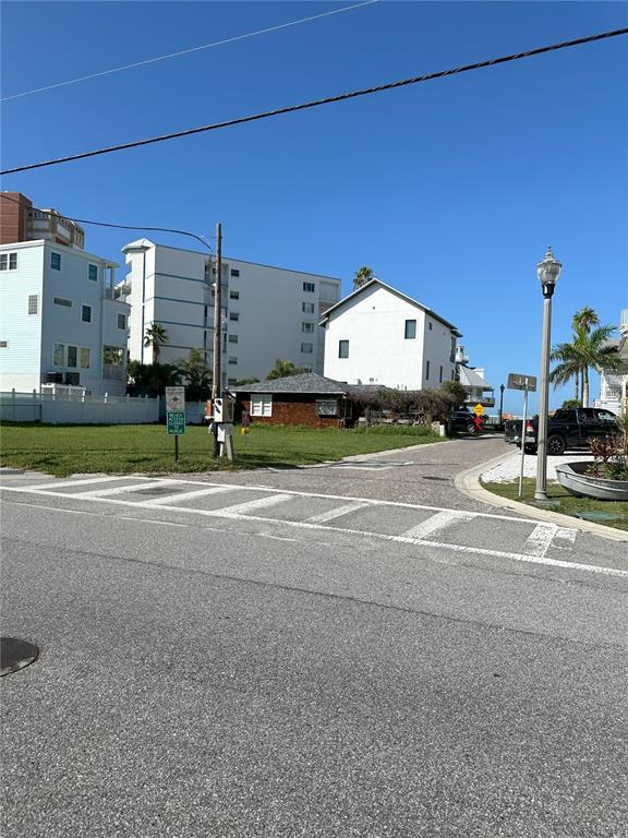 A paved street leads toward a grassy lot with nearby houses and a street lamp — GULF BOULEVARD, REDINGTON SHORES, FL