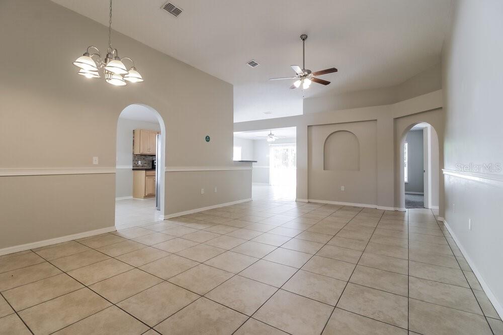 A tiled dining area leads into a kitchen and living space with arched doorways — 2959 ELBIB DRIVE, ST CLOUD, FL