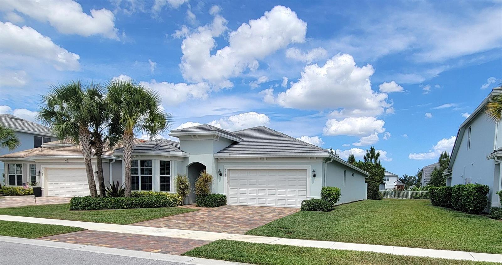A single-story house with a tiled roof, white garage, and palm trees in the front yard — 5324 Star Rush Lane, Lake Worth FL 33467, LAKE WORTH, FL