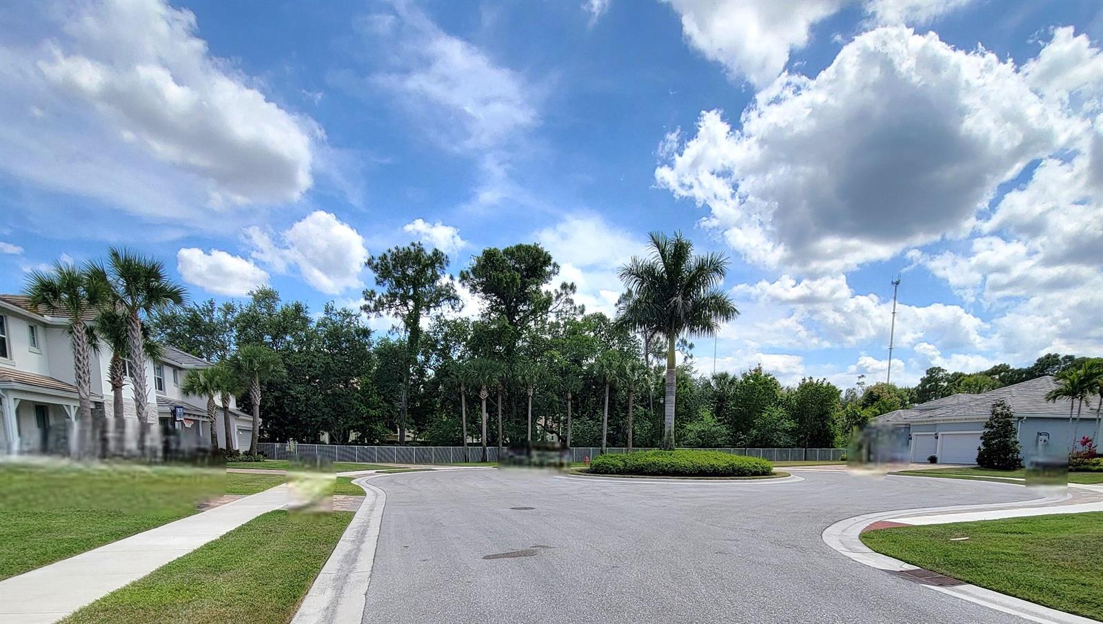 A residential street features a circular driveway, palm trees, and houses under a cloudy sky — 5324 Star Rush Lane, Lake Worth FL 33467, LAKE WORTH, FL