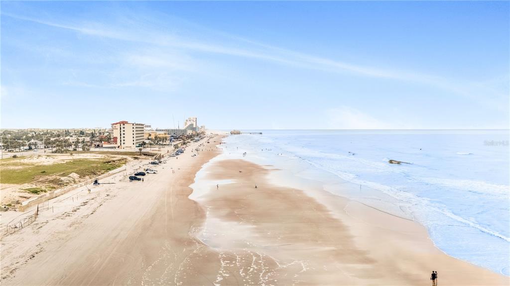 An aerial view of a sandy beach with parked cars and oceanfront buildings in Florida — 935 S ATLANTIC AVENUE, DAYTONA BEACH, FL