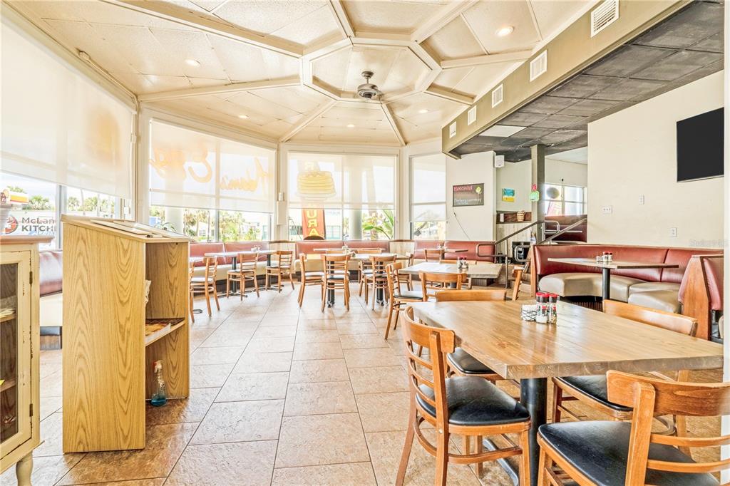 A restaurant dining area features wooden tables, chairs, booths, and a large geometric ceiling — 935 S ATLANTIC AVENUE, DAYTONA BEACH, FL
