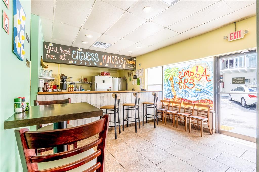 A restaurant interior features a bar with stools, a chalkboard sign, and a window view — 935 S ATLANTIC AVENUE, DAYTONA BEACH, FL