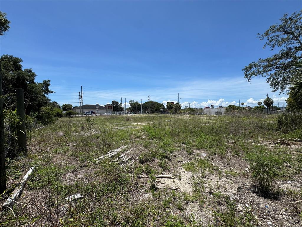 A vacant, grassy lot with scattered debris under a clear blue sky — 8725 W WATERS AVENUE, TAMPA, FL