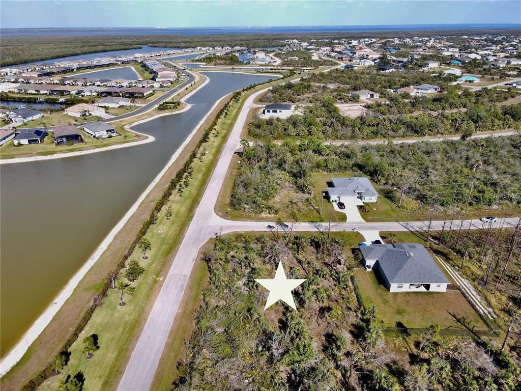 An aerial view shows a vacant, star-marked residential lot next to a house and road — 8045 THRUSO ROAD, PORT CHARLOTTE, FL