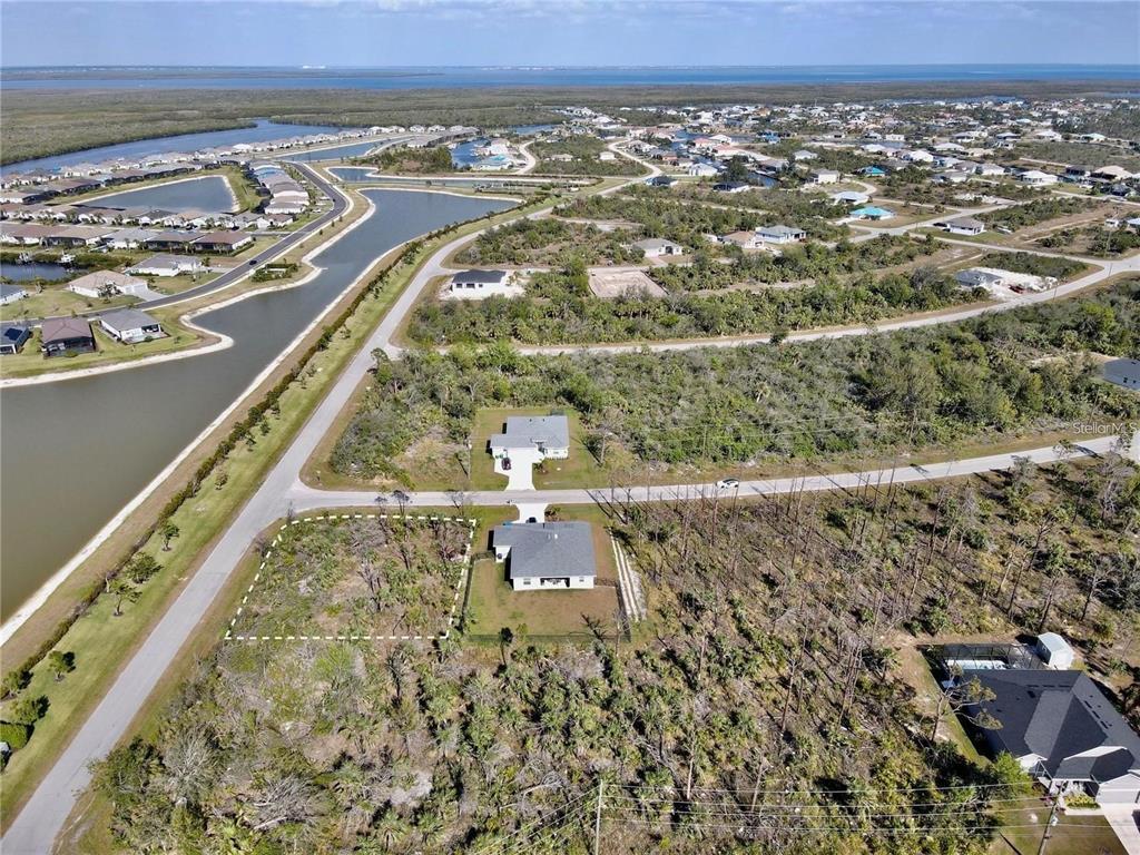 An aerial view shows a residential lot outlined in white next to a house — 8045 THRUSO ROAD, PORT CHARLOTTE, FL