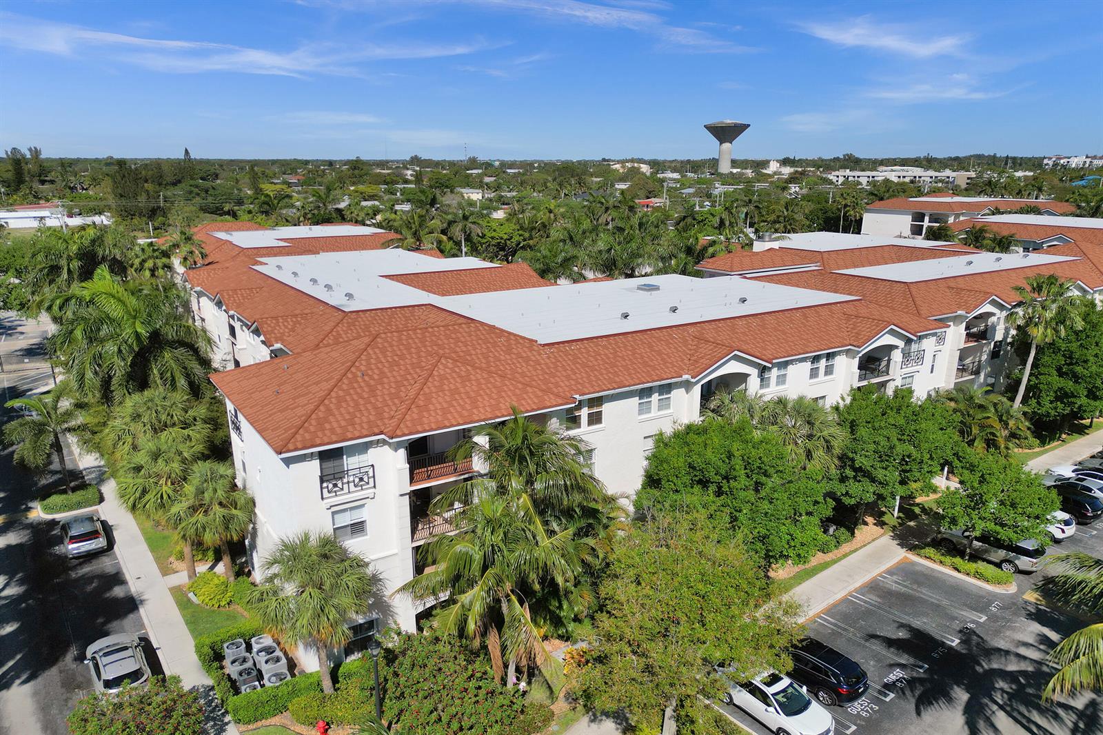 An aerial view shows a multi-story apartment building with a terracotta-colored roof and surrounding parking — 2113 Tuscany Way, Boynton Beach FL 33435, BOYNTON BEACH, FL