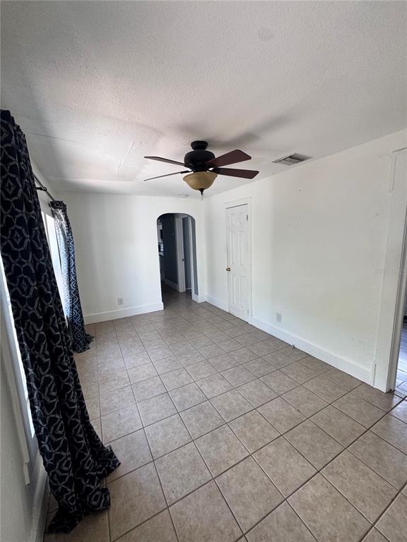 A room with white walls, tile flooring, a ceiling fan, and a doorway leading elsewhere — 3134 17TH STREET N, ST PETERSBURG, FL