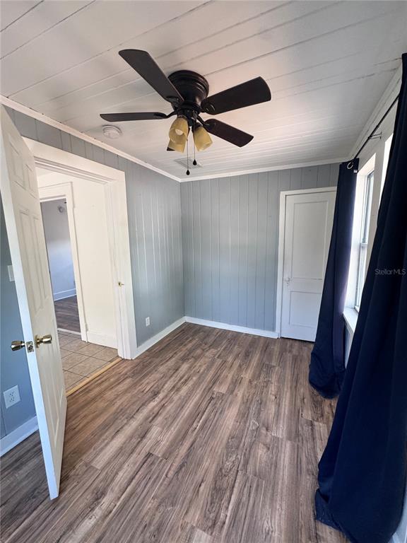 A room with wood-look flooring, gray paneled walls, a white plank ceiling, and a ceiling fan — 3134 17TH STREET N, ST PETERSBURG, FL