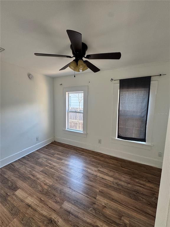 A bedroom with white walls, wood-look flooring, a ceiling fan, and two windows — 3134 17TH STREET N, ST PETERSBURG, FL