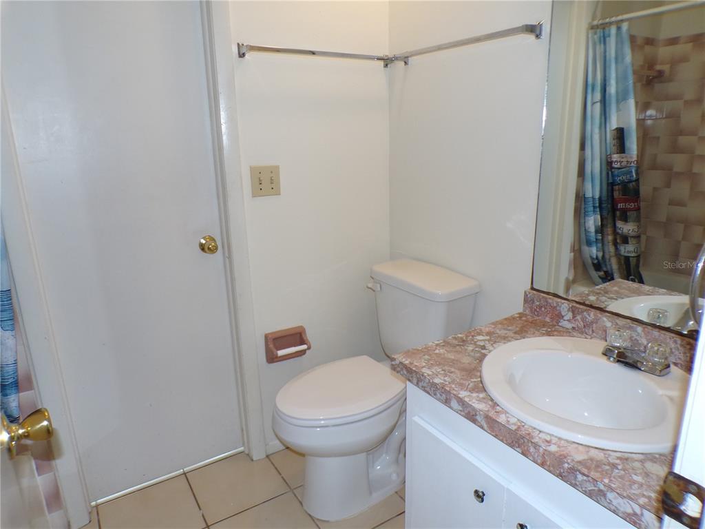 A kitchen features white appliances, white cabinets, and a red countertop — 10104 WILLMINGTON BOULEVARD, ENGLEWOOD, FL