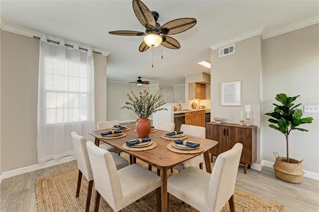 A dining room features a wooden table, six chairs, a ceiling fan, and a rug — 1195 VILLAGIO CIRCLE UNIT 101, SARASOTA, FL