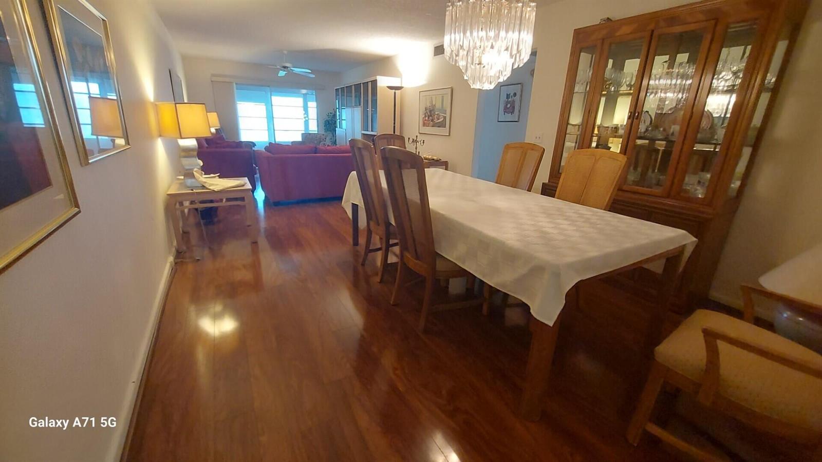 A dining room with a wooden table and chairs leads into a living area — 2001 Yarmouth Drive # 2001, Boca Raton FL 33434, BOCA RATON, FL