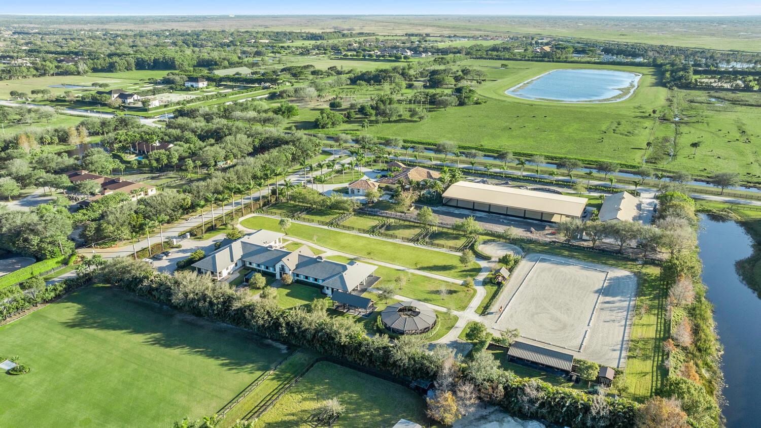 An aerial view of a large equestrian estate featuring a house, stables, and riding arena — 4915 Stables Way, Wellington FL 33414, WELLINGTON, FL