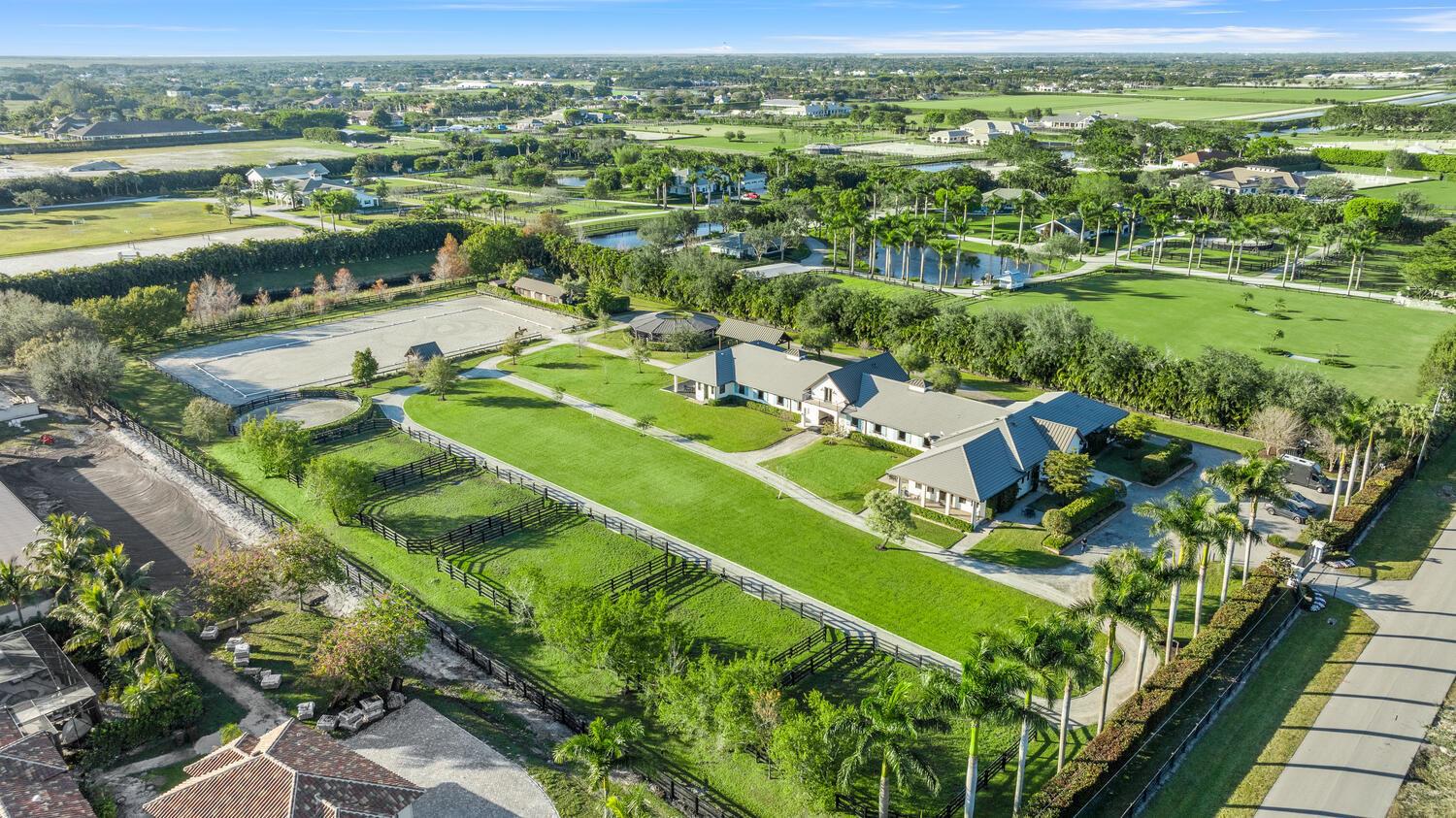 An aerial view shows a sprawling equestrian estate with a large house, stables, and paddocks — 4915 Stables Way, Wellington FL 33414, WELLINGTON, FL
