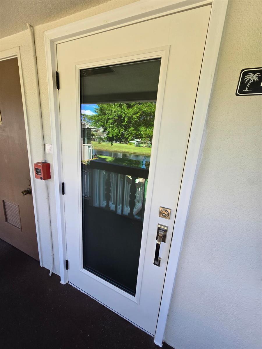 A white exterior door with a large glass panel is mounted on a beige wall — 43 Markham B # 43, Deerfield Beach FL 33442, DEERFIELD BEACH, FL