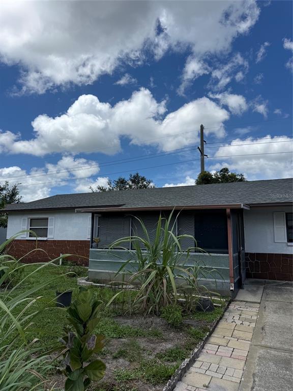 A single-story house with a screened-in porch, stone-patterned lower siding, and a paved walkway — 3305 JOE LOUIS DRIVE, SARASOTA, FL