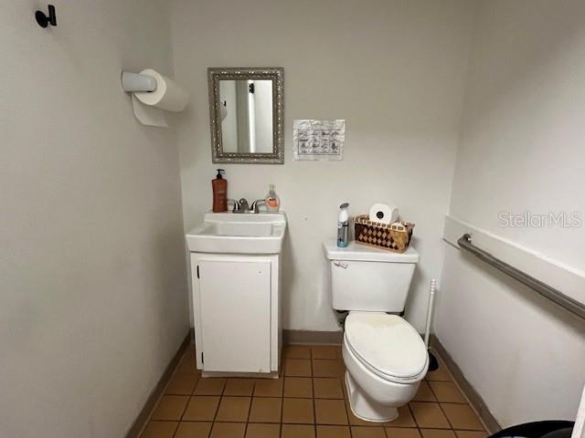 A small bathroom features a white pedestal sink, a toilet, and a wall-mounted mirror — 37037 STATE ROAD 54, ZEPHYRHILLS, FL