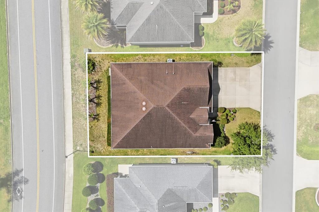 An aerial view shows a residential house with a brown roof and a concrete driveway — 3087 BLACKSTOCK WAY, THE VILLAGES, FL