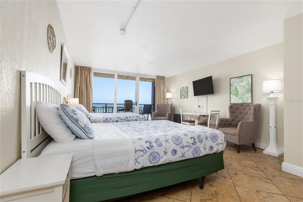 A hotel room features two beds, a balcony with ocean views, and tiled flooring — 2301 S ATLANTIC AVENUE UNIT 403, DAYTONA BEACH, FL