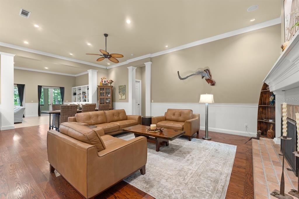 A living room with leather furniture, a wooden coffee table, and a fireplace — 2659 PIONEER TRAIL, NEW SMYRNA BEACH, FL
