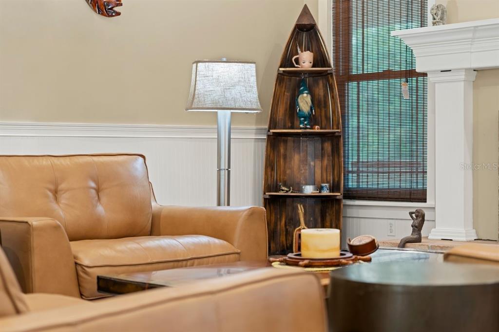 A living room features a leather sofa, a boat-shaped shelf, and a floor lamp — 2659 PIONEER TRAIL, NEW SMYRNA BEACH, FL