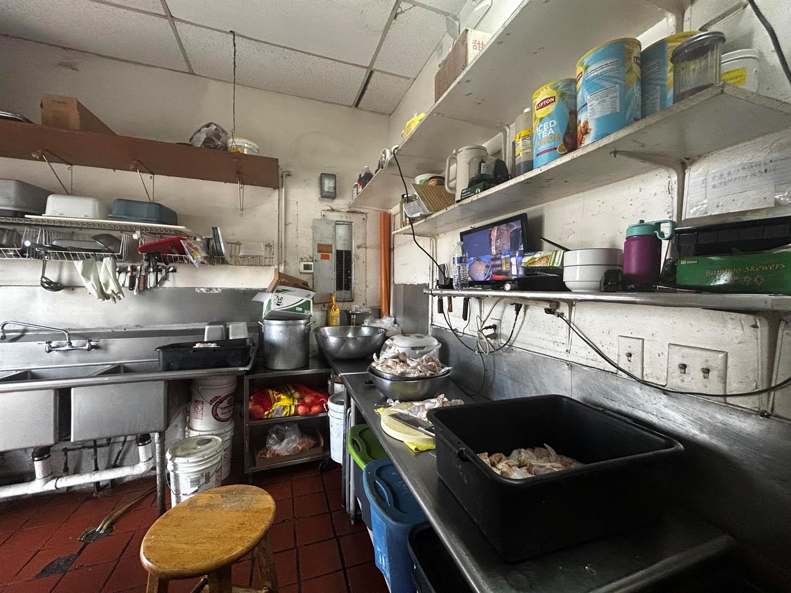 A commercial kitchen features stainless steel sinks, metal shelving, and various food preparation containers — 2623 W Atlantic Boulevard, Pompano Beach FL 33069, POMPANO BEACH, FL