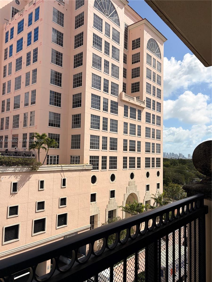 A view from a balcony looking toward a tall, pink multi-story residential building — 55 Merrick Way # 534, Coral Gables FL 33134, CORAL GABLES, FL