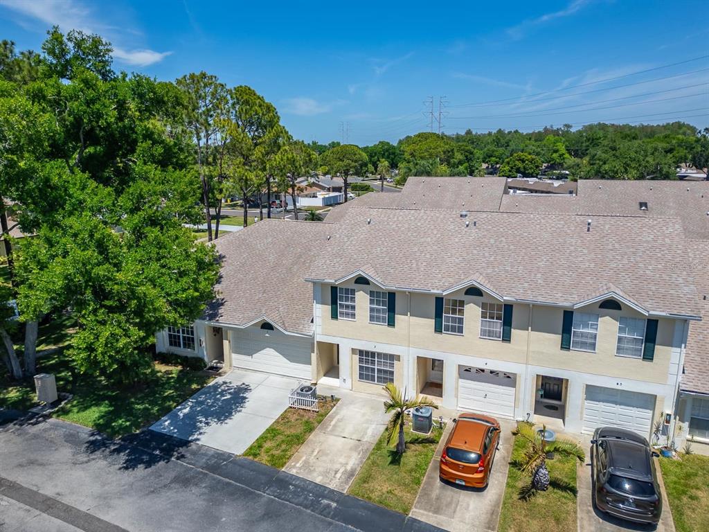 An aerial view of a multi-unit townhouse complex with driveways and parked cars — 658 GREEN VALLEY ROAD UNIT B3, PALM HARBOR, FL